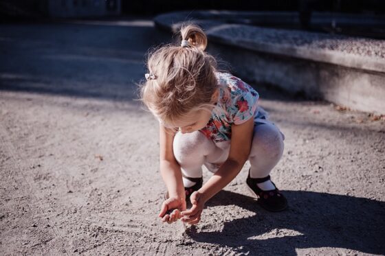 Una bambina si sporca le mani con la terra