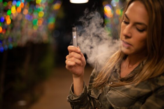 Una donna fuma una sigaretta elettronica 