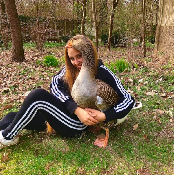 Lisa Mantovani abbraccia un'oca nella natura