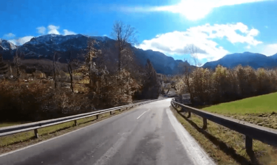 strada che taglia pato, alberi e montagne all'orizzonte (panorama austriaco )