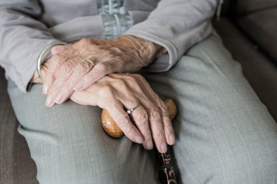 Dettaglio sulle mani di un'anziana, che stringono un bastone