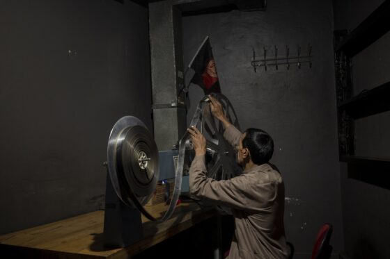 Rahmatullah Ezati  controlla una pellicola cinematografica nel cinema Ariana,a Kabul. Anche se il cinema è stato chiuso dal governo talebano, i suoi dipendenti continuano a presentarsi al lavoro quotidianamente nella speranza di ricevere il salario (Foto: Bram Janssen, The Associated Press)